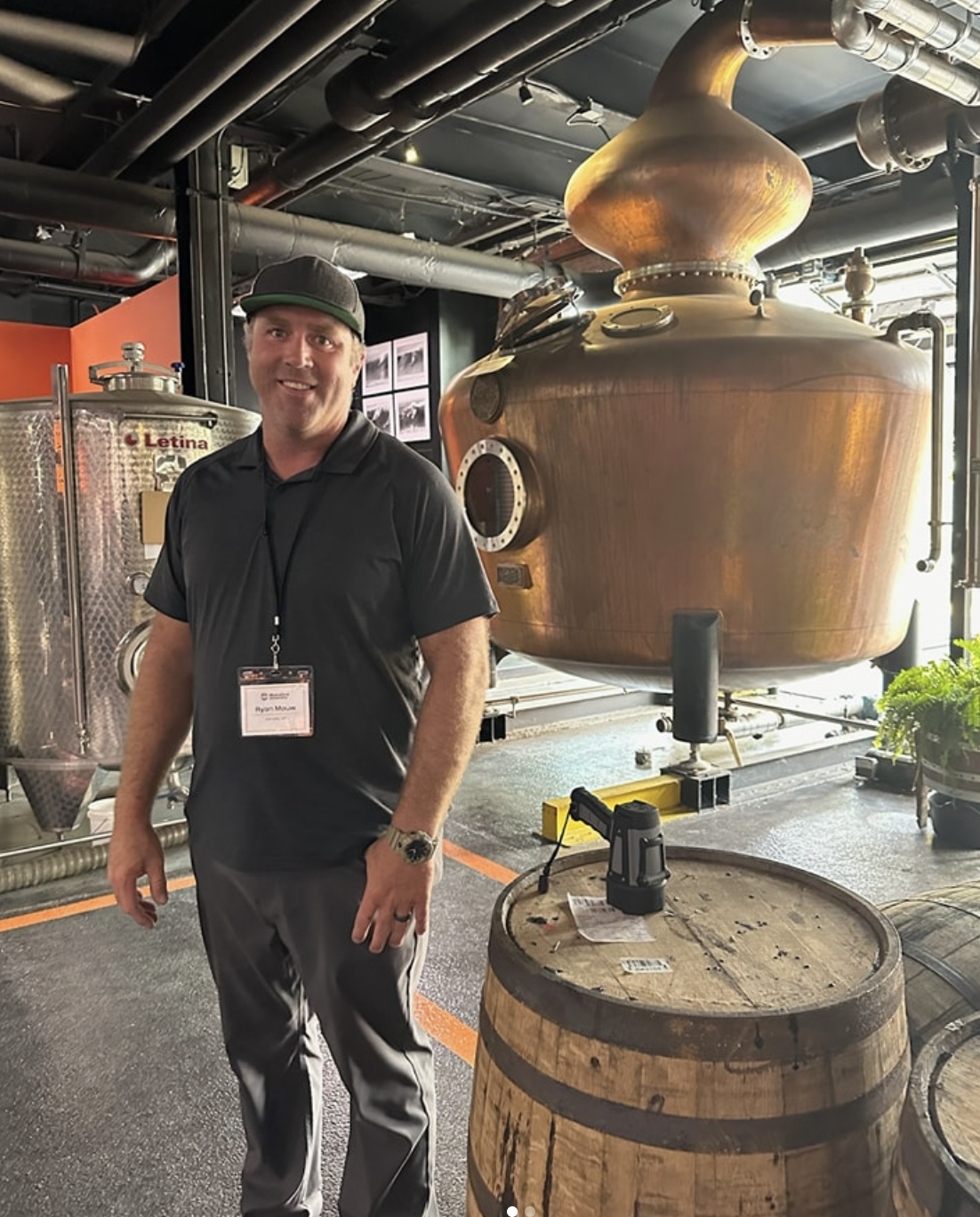 Ryan Mouw smiling in front of apple brandy distilling equipment at Swanson’s Mountain View Orchard